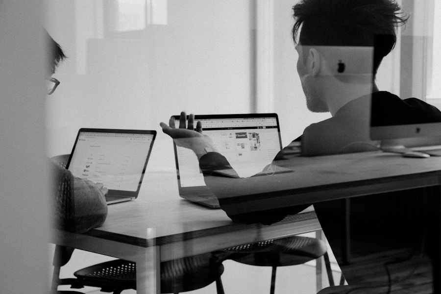 Two colleagues in focused discussion at laptops, representing an urgent crisis response session