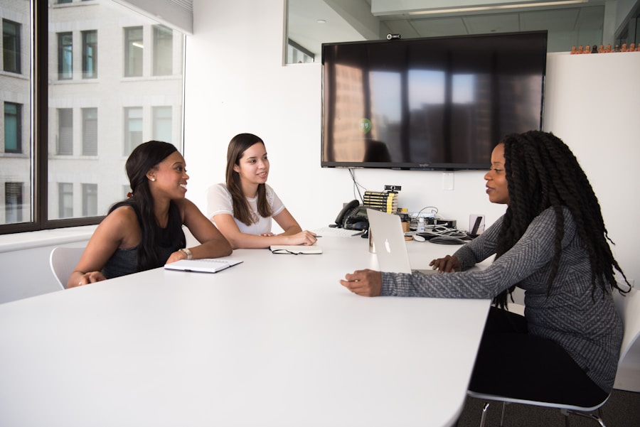 Women in a corporate office meeting representing the Gender Pay Gap Bot's accountability campaign targeting corporate IWD posts