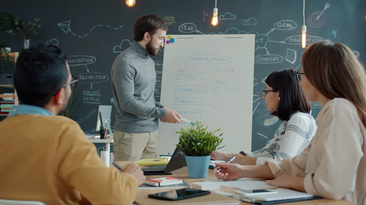 Marketing team collaborating around a whiteboard to plan blog content and CTA placement strategy