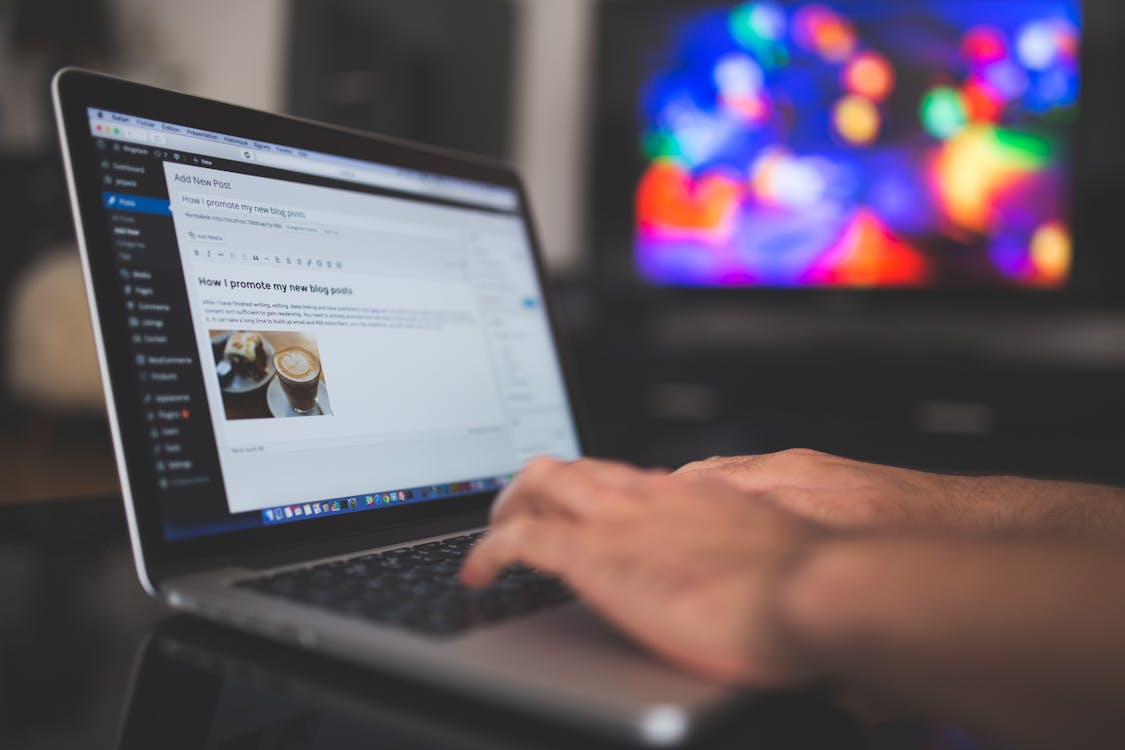 Writer actively typing a blog post on a laptop, illustrating the focused execution behind E-E-A-T content signals
