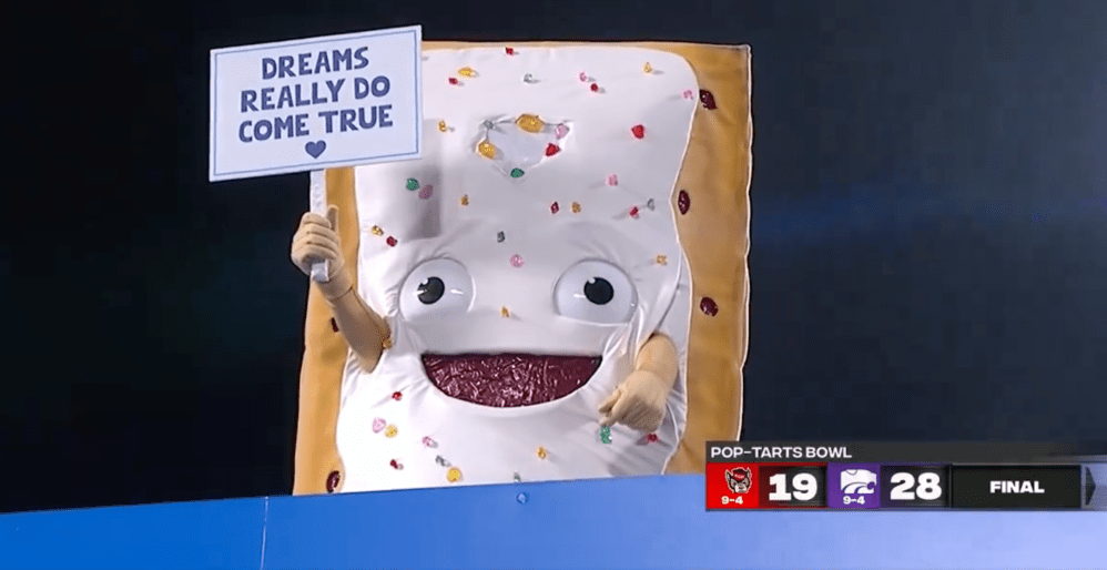 A life-sized Pop-Tarts mascot being lowered into a giant toaster on a college football field before the winning team eats it