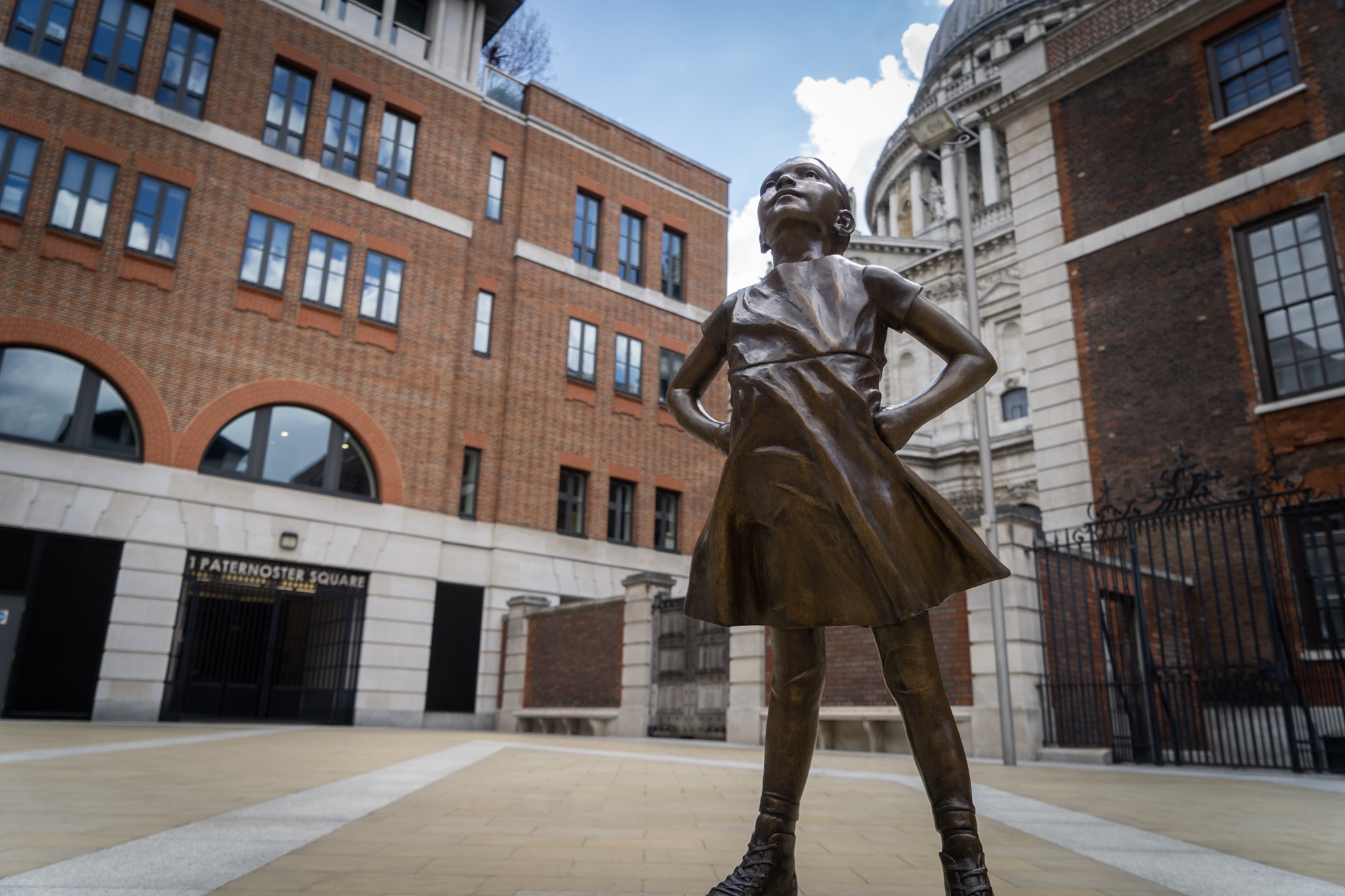 The bronze Fearless Girl statue standing with hands on hips, the defiant sculpture at the heart of the campaign
