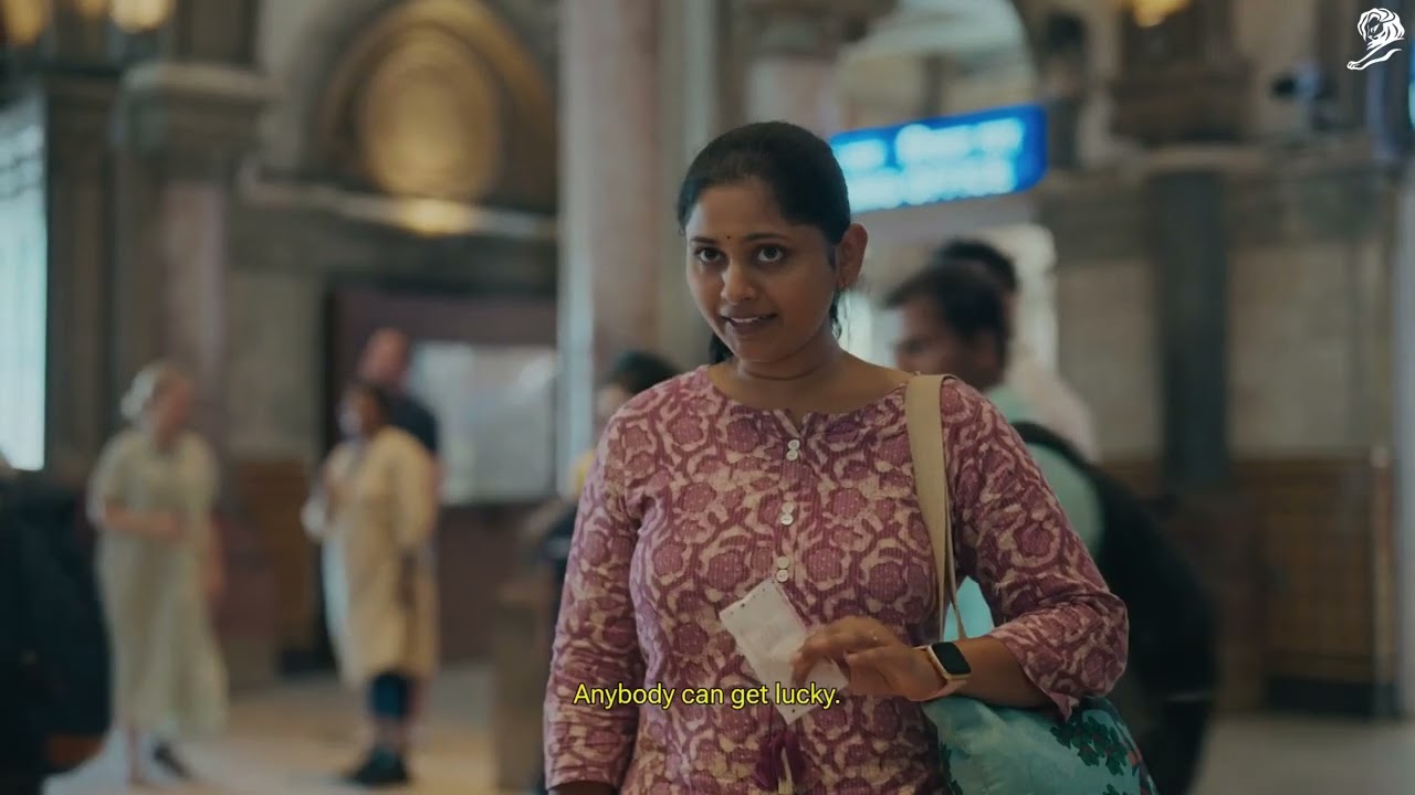 A woman at a Mumbai railway station holding a train ticket in a still from the Lucky Yatra campaign film